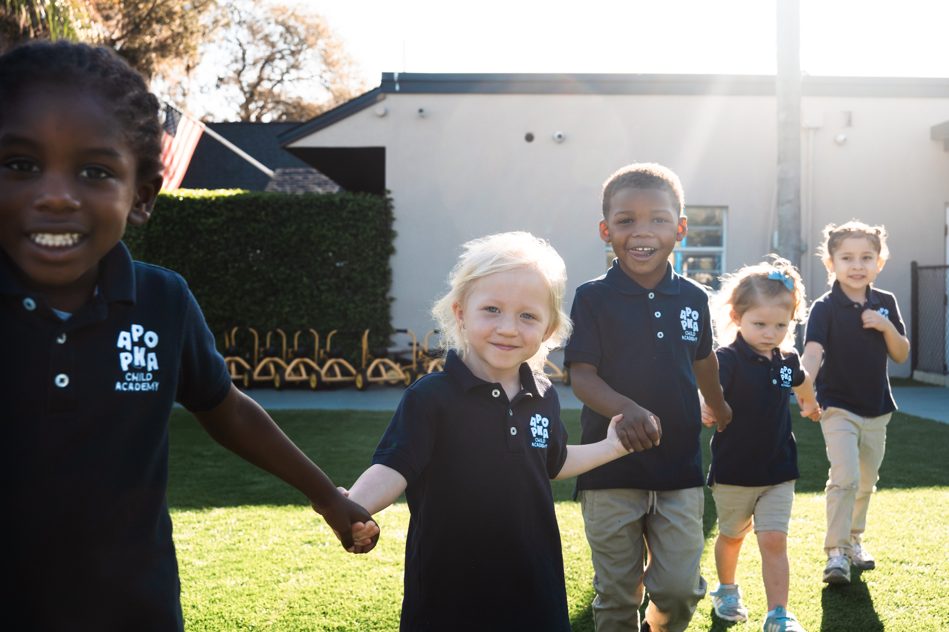 ACA students holding hands and running on the playground